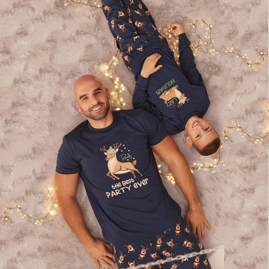 Muškarac i dečak leže u Jasmil novogodišnjim pidžamama u teget boji