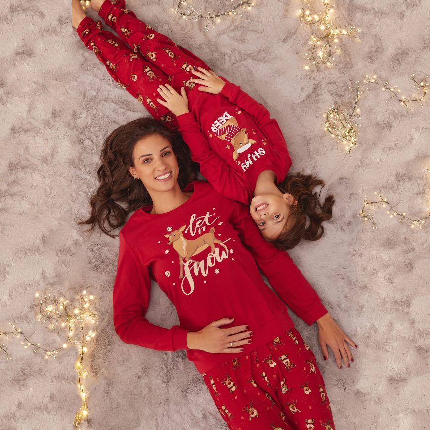 Žena i devojčica leže u Jasmil novogodišnjim pidžamama crvene boje